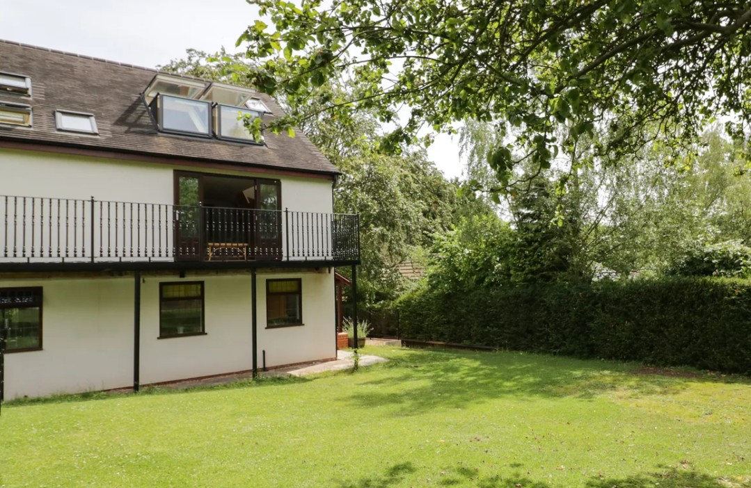 Cozy cottage interior with exposed beams and wood burner in Bentley Heath